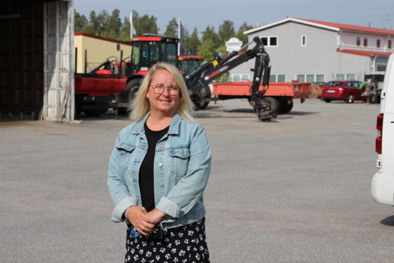 Benita står framför en fordonspark, bild.